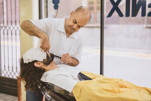 A barber trims a client's beard at a modern barbershop with bright and cozy ambiance.