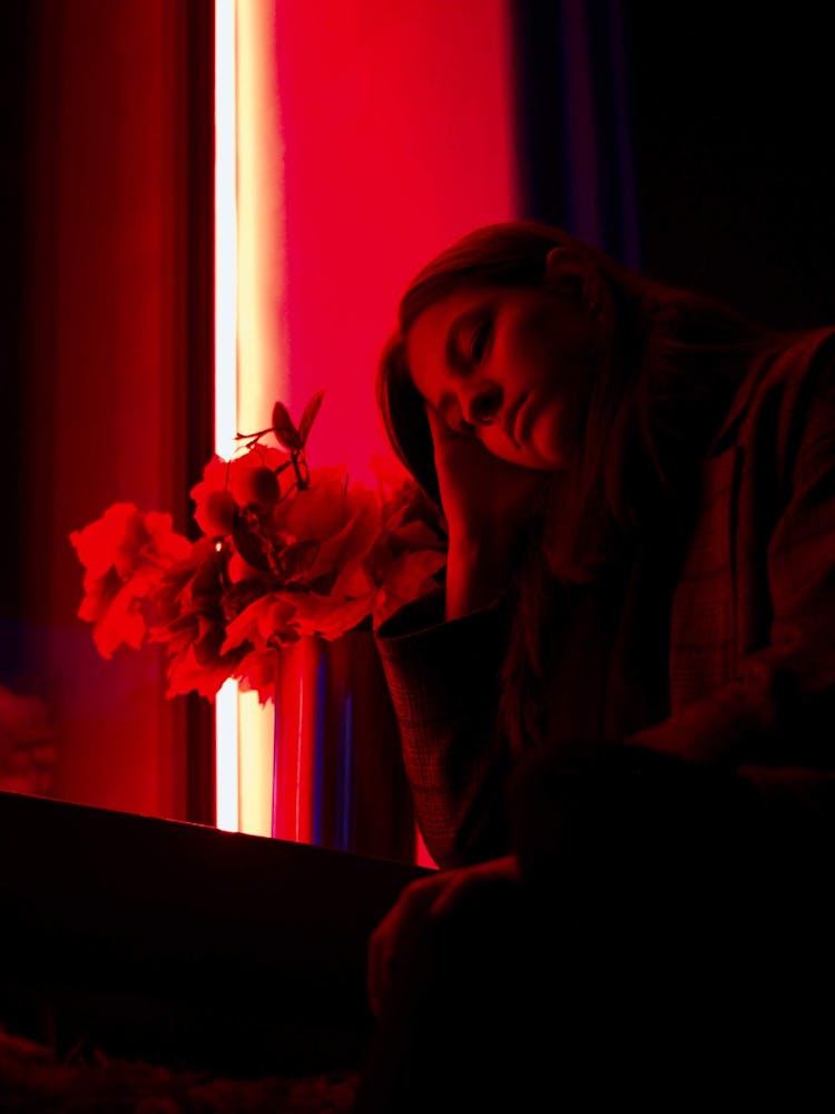 A Sad Woman Staring At Flowers