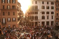 日落时分，罗马历史悠久的街道上挤满了熙熙攘攘的人群，营造出充满活力的城市氛围