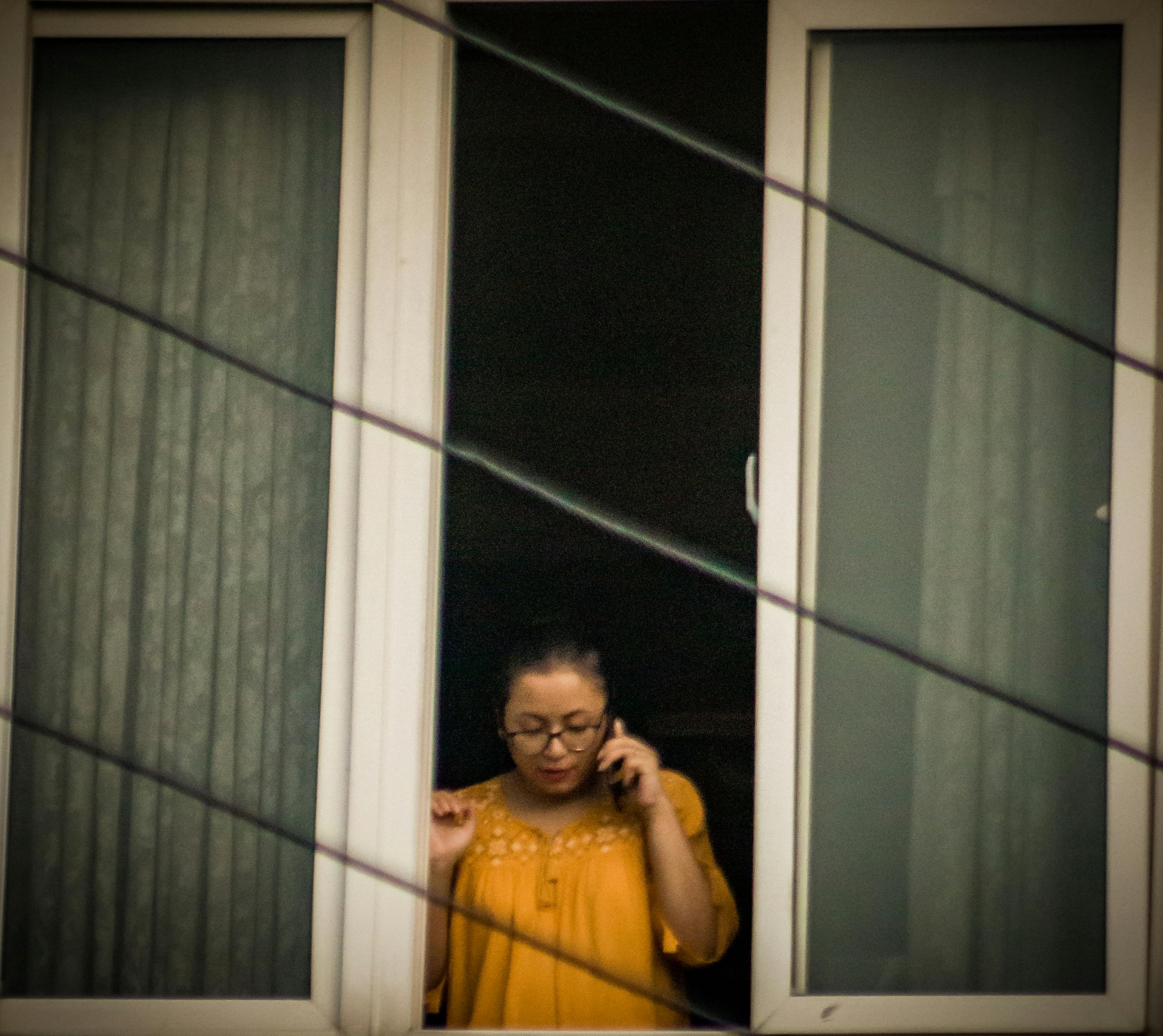 Mujer joven sonriendo mientras cose una prenda de ropa, simbolizando la moda sostenible y el upcycling.