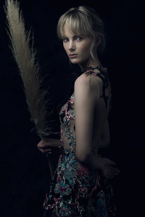 Woman in Printed Dress Holding a Pampas Grass