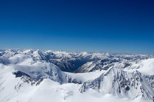 Free Snow Capped Mountains Under a Clear Blue Sky Stock Photo