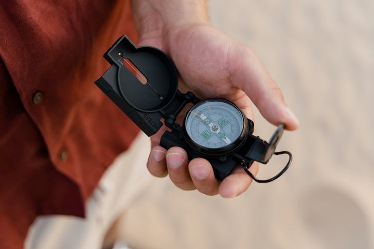 Person Holding A Black Compass 