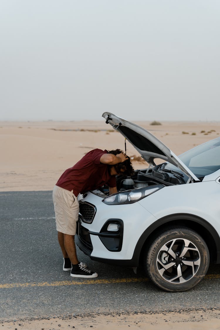 A Man Checking His Broken Car