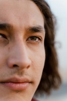 Close-up shot of a young man's face with focus on his eyes and thoughtful expression.