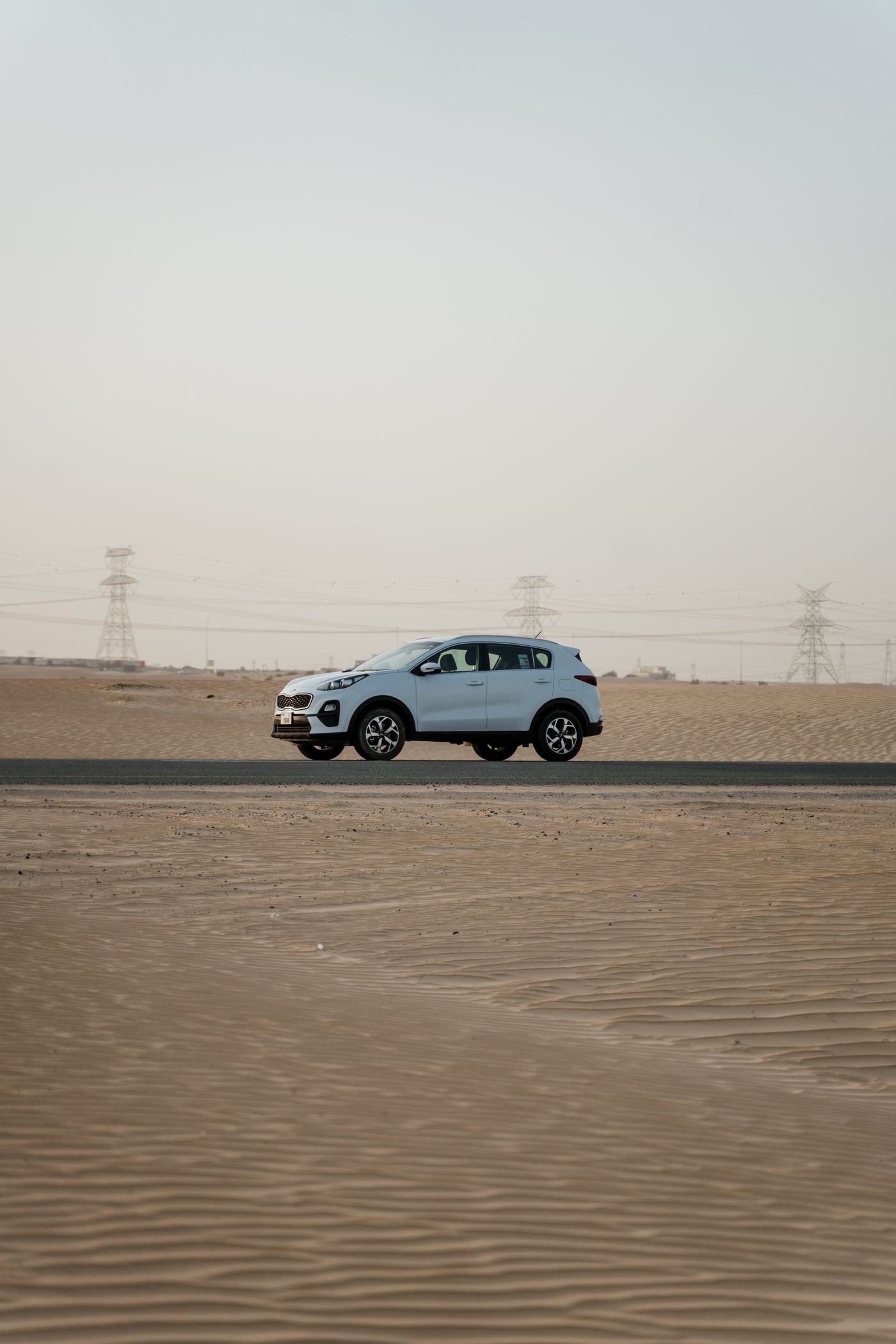 White SUV on a long open desert road