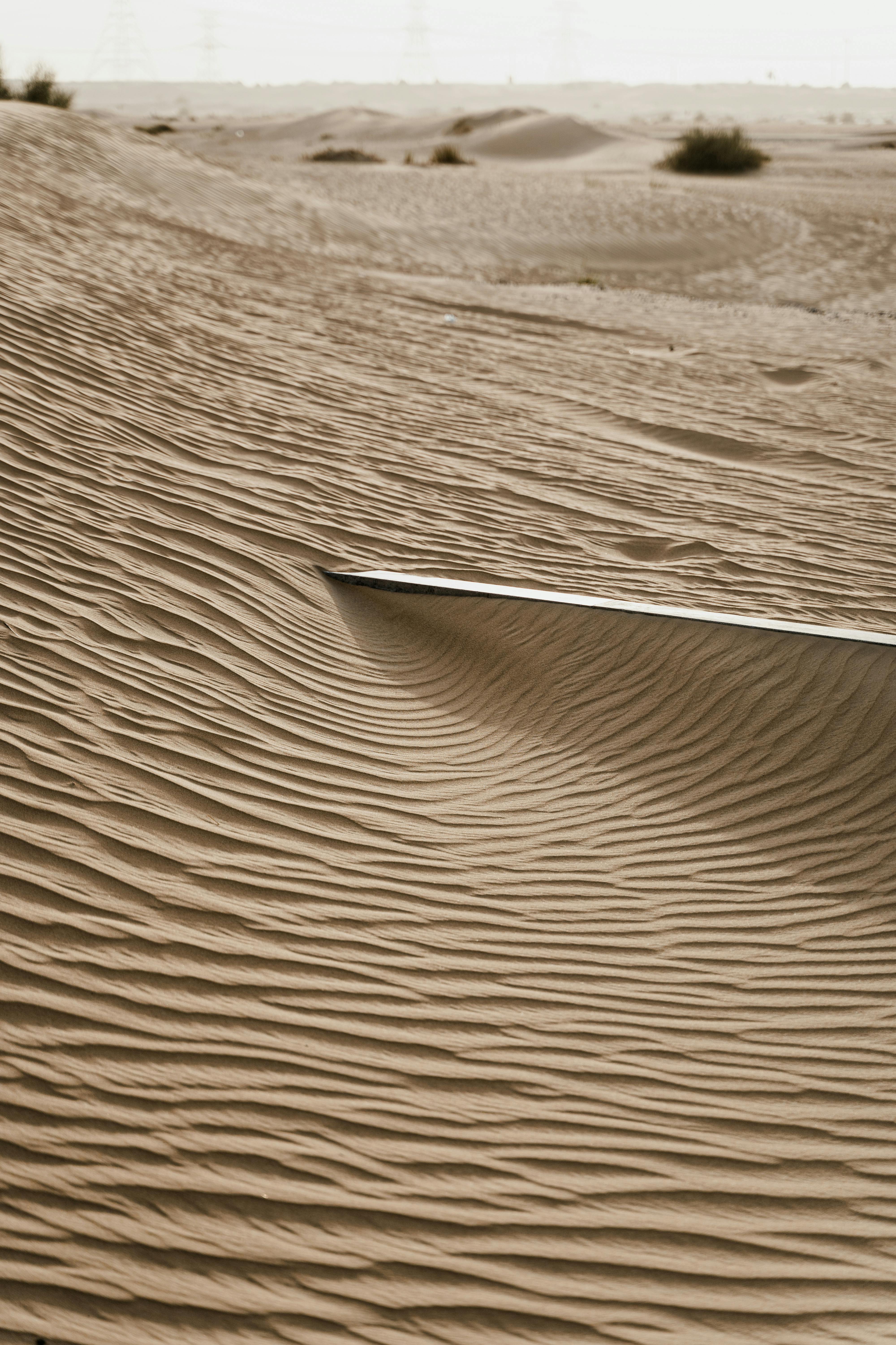 Captivating close-up of sand dunes showcasing intricate wind patterns under natural light.
