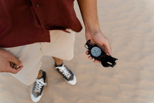 Person in the Desert Holding a Black Compass