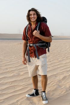 Man with backpack enjoying a sunny desert adventure, perfect for travel-themed projects.