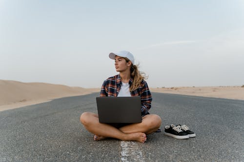 Free A Woman Sitting on the Road with Her Laptop Stock Photo