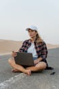 Woman Sitting on the Road Using a Laptop