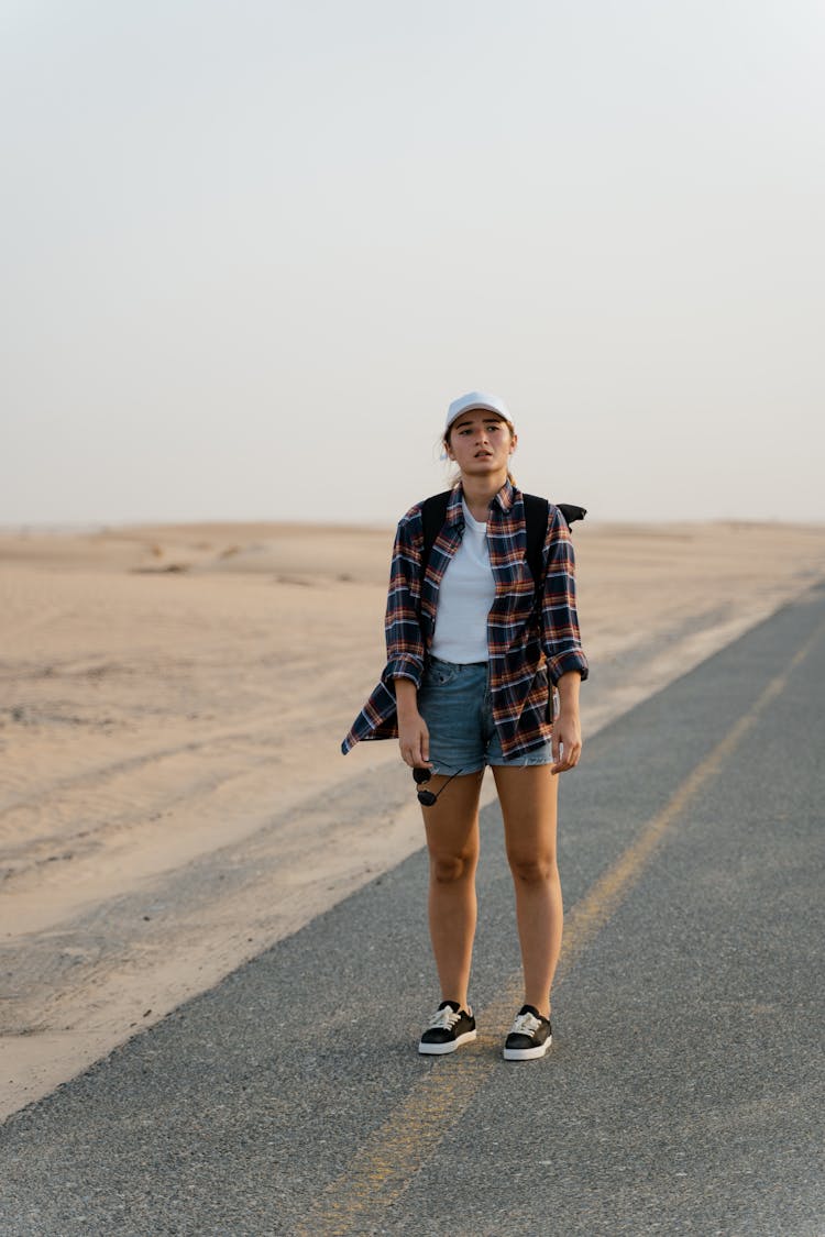 Lost Woman Standing On The Road In A Desert