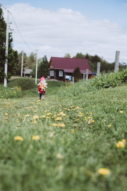 Girl Walking on Grass with Yellow Flowers