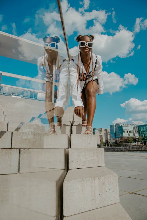 Woman Wearing Sunglasses Posing near a Glass