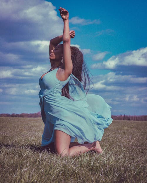 Woman in Blue Dress Leaning on Grass