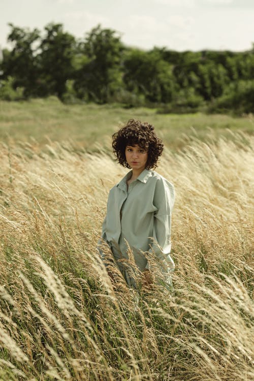 Curly Woman in the Grass Field Posing