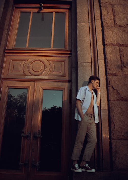 Man with Polo Open Standing near a Wooden Door