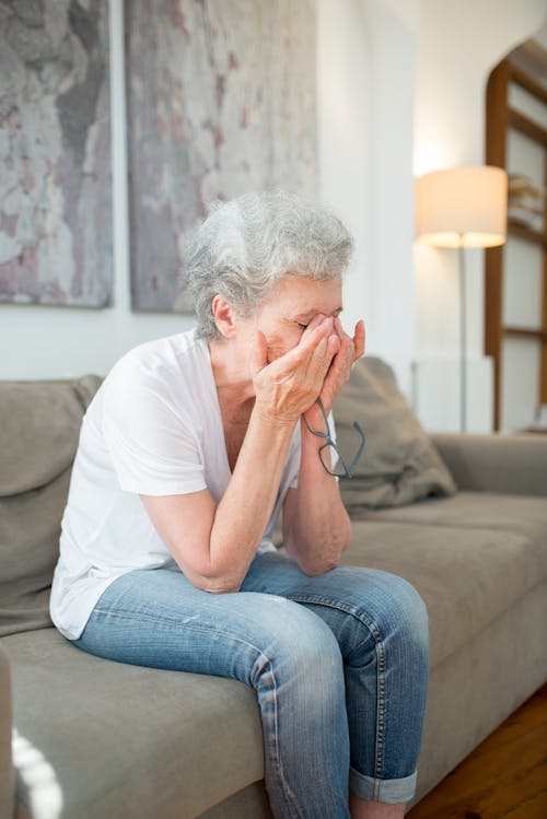 Crying Elderly Woman Sitting on a Gray Couch