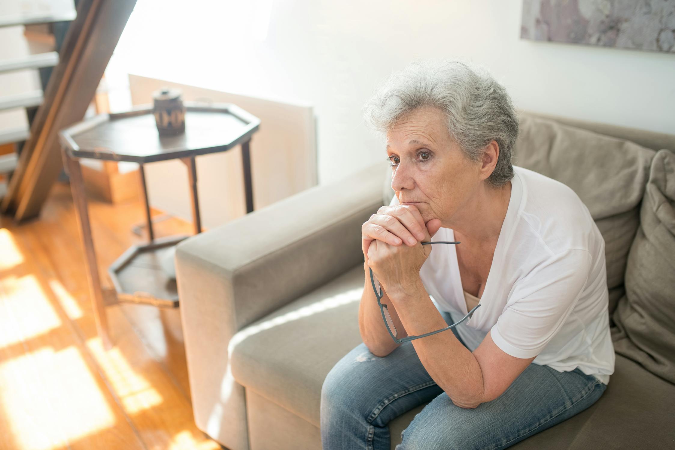 Gray Haired Woman Thinking with her Hands under her Chin lost track of time dementia symptoms