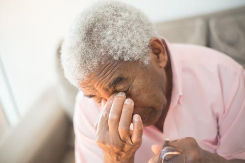 A Close-Up Shot of a Man in a Pink Shirt Grieving