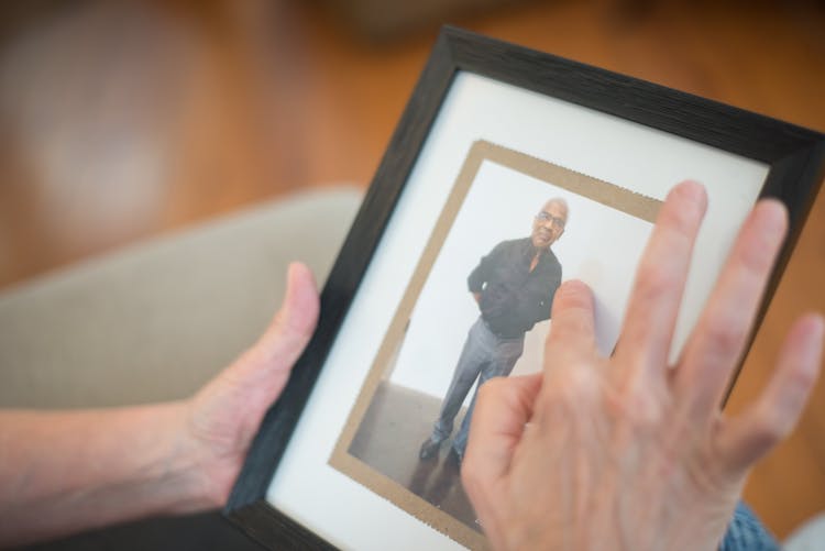 Person Touching Photo In The Picture Frame 