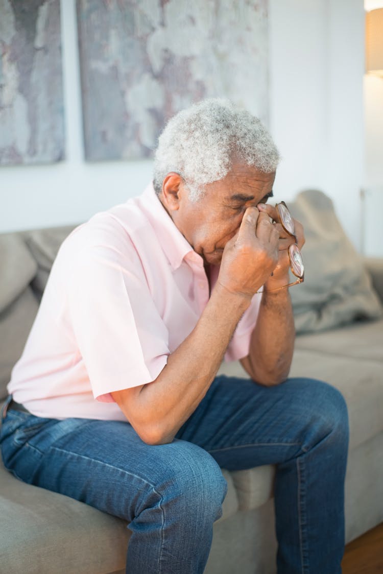 Gray Haired Man Sitting On The Couch Crying 