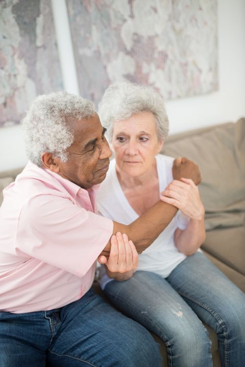 Free Warm and intimate portrait of an elderly couple sitting closely on a couch, sharing a heartfelt embrace. Stock Photo