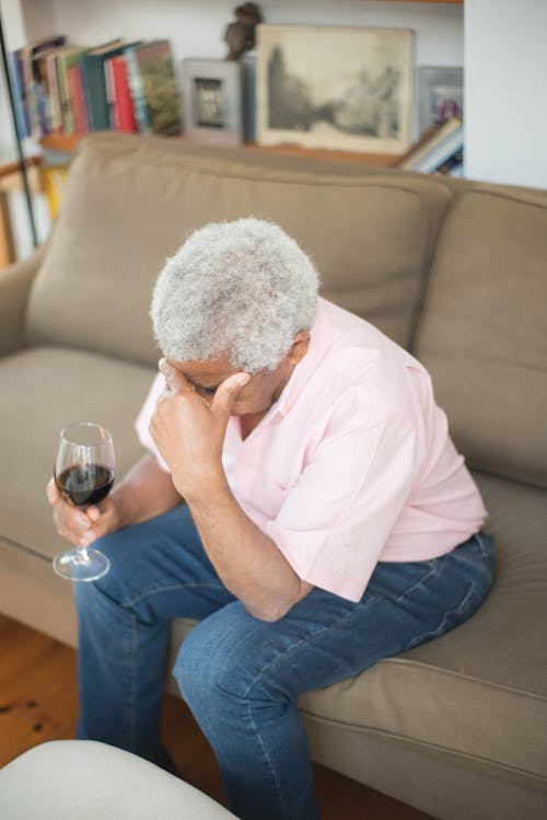 Elderly Man in Pink Button Up Shirt Holding a Glass of Wine