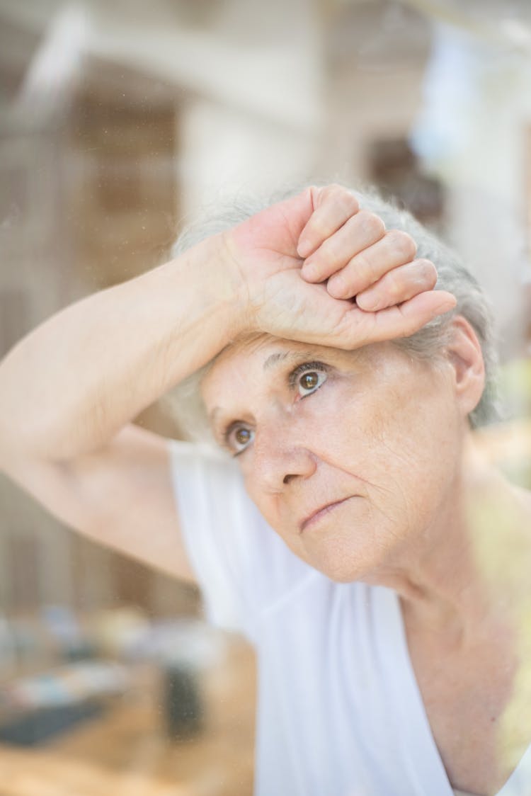 Elderly Woman Leaning On A Glass