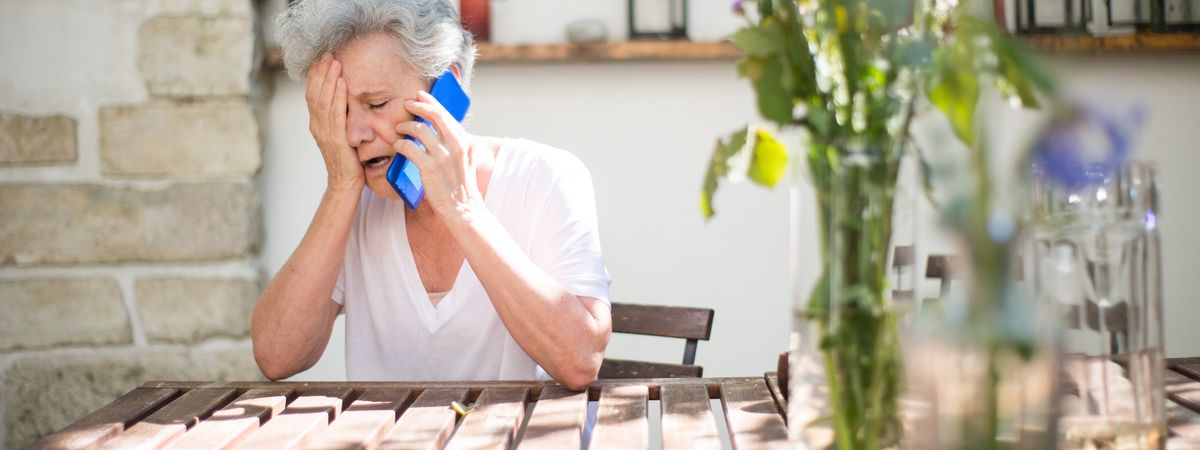 Mujer mayor preocupada hablando por teléfono