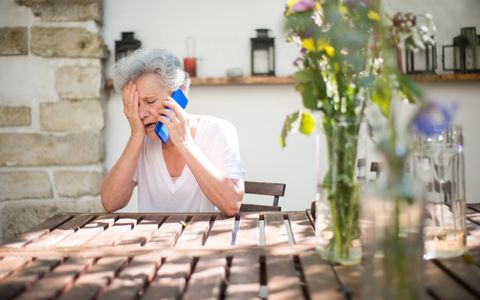 Mujer mayor preocupada hablando por teléfono