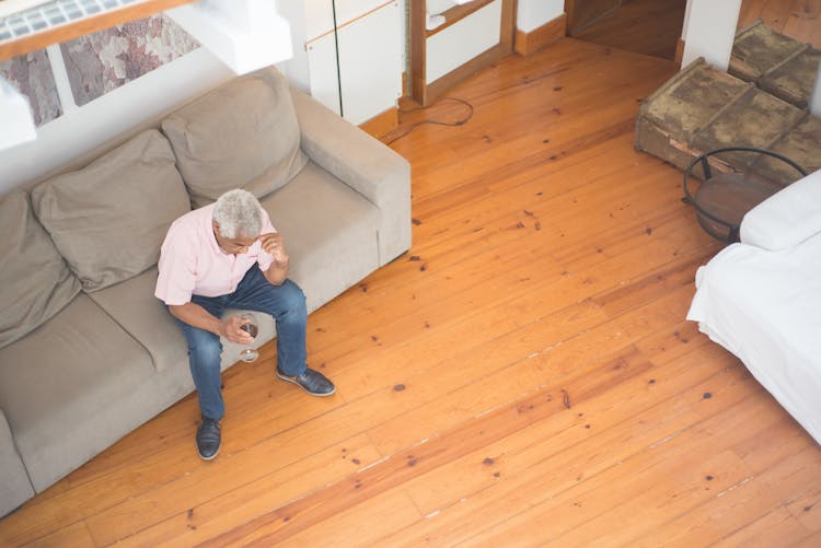 An Elderly Man Drinking Alcohol At Home