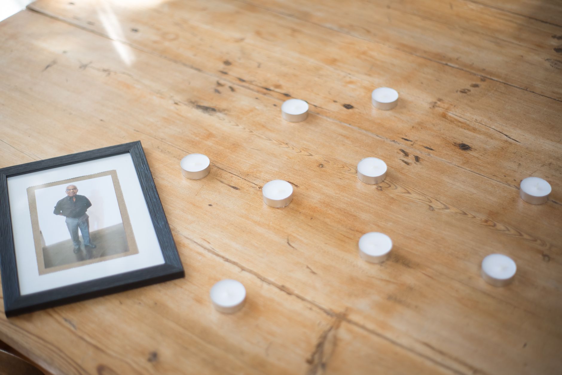 dog collar and lit candle on wooden surface, memorial ritual for pet who has passed