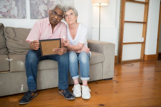 Elderly Man Holding a Picture Frame Beside an Elderly Woman