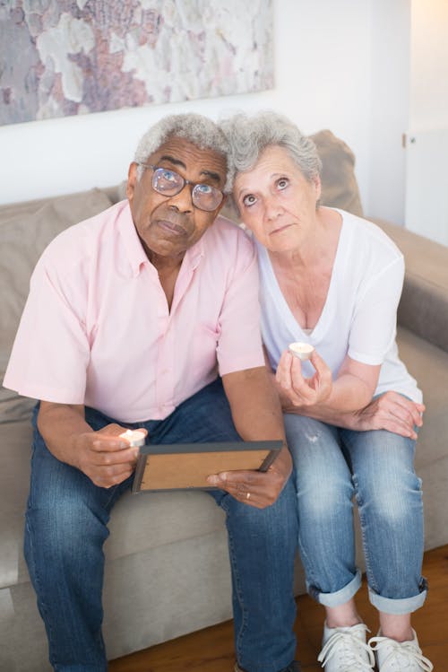Elderly Couple Sitting on Sofa While Looking Up