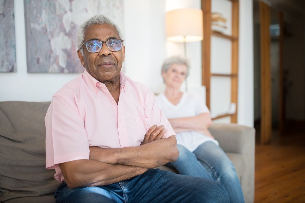 Two senior adults sitting comfortably on a sofa in a cozy living room