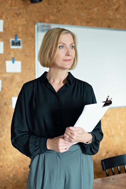 Free Woman in Black Long Sleeve Shirt Holding A Paperwork Stock Photo