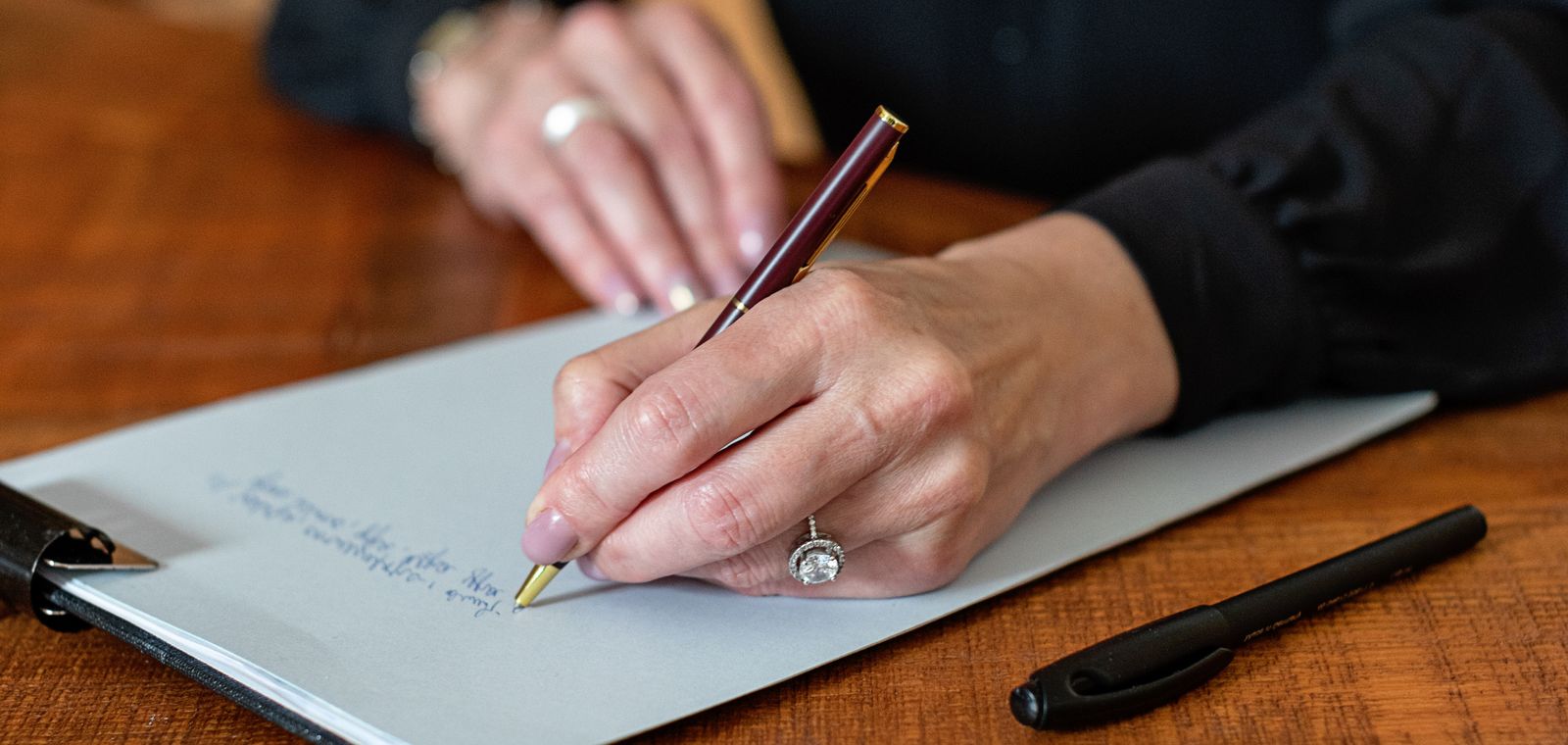 Person writing notes on a clipboard