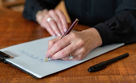 Person writing notes on a clipboard