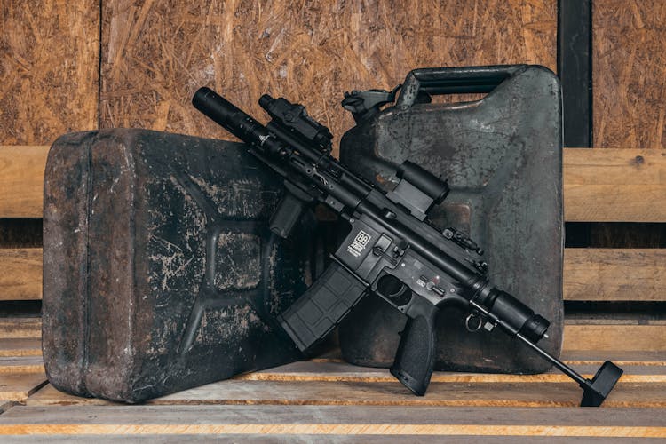 Rifle And Canisters On Wooden Background