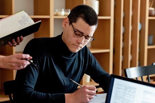 Man in Black Long Sleeves Shirt Writing 