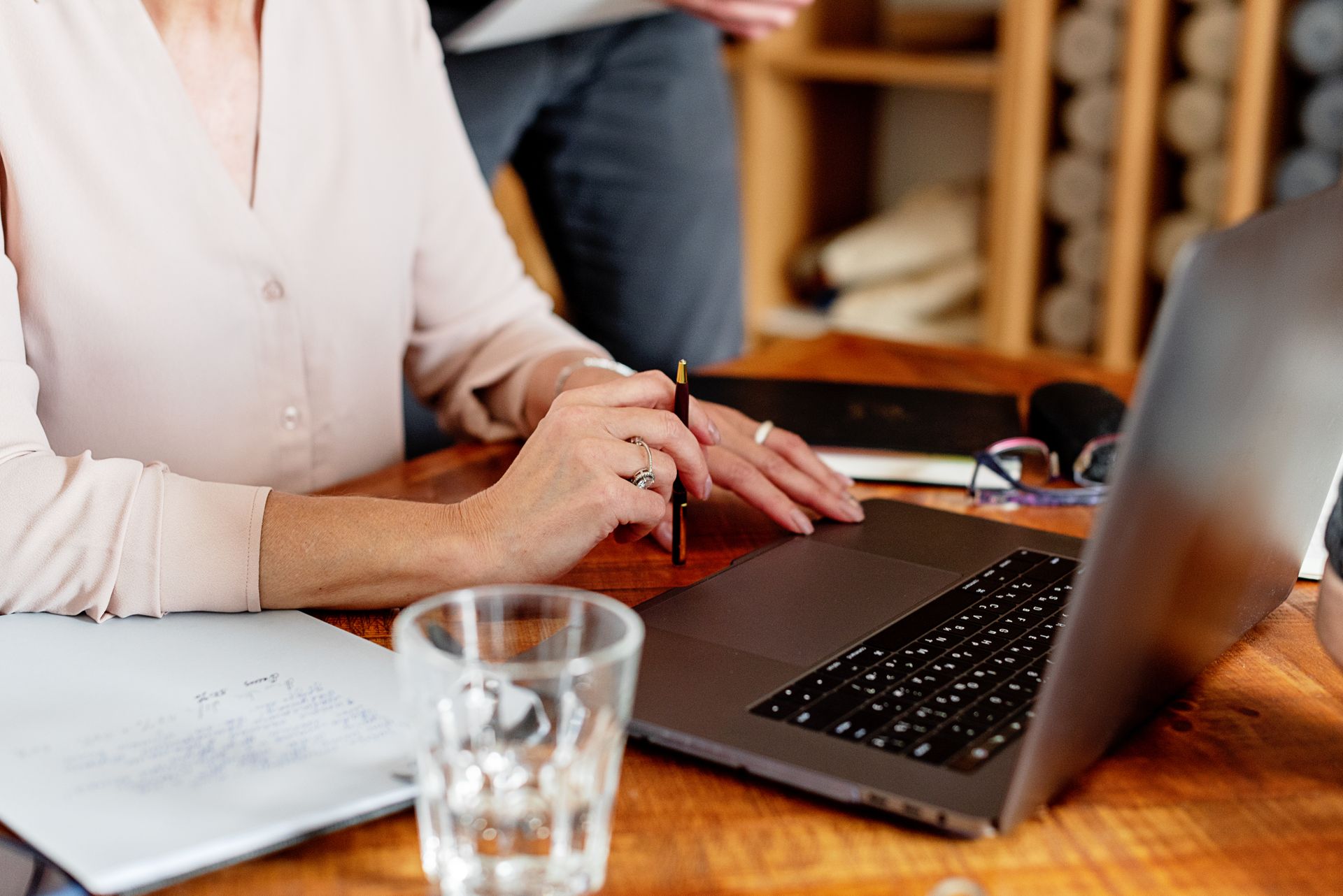 Beratungssituation mit Unterlagen und Laptop am Schreibtisch.