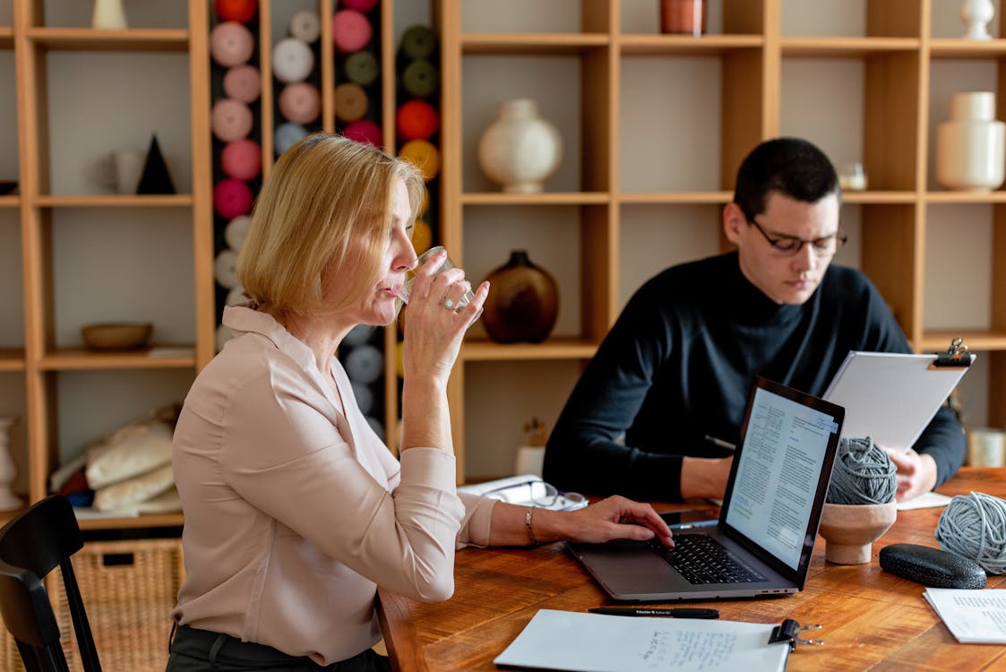 Free A Woman Drinking Water While Sitting at the Meeting Table Stock Photo