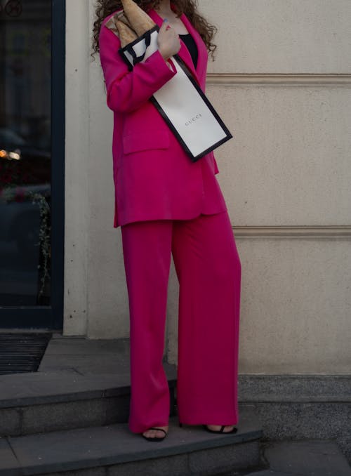 Photo of a Woman in Pink Clothes Holding a Black and White Bag