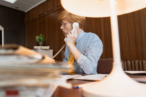 Free Photo of a Man with a Yellow Necktie Talking on a Telephone Stock Photo