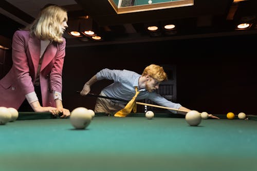 Free A Woman Looking at a Man Playing Billiards Stock Photo