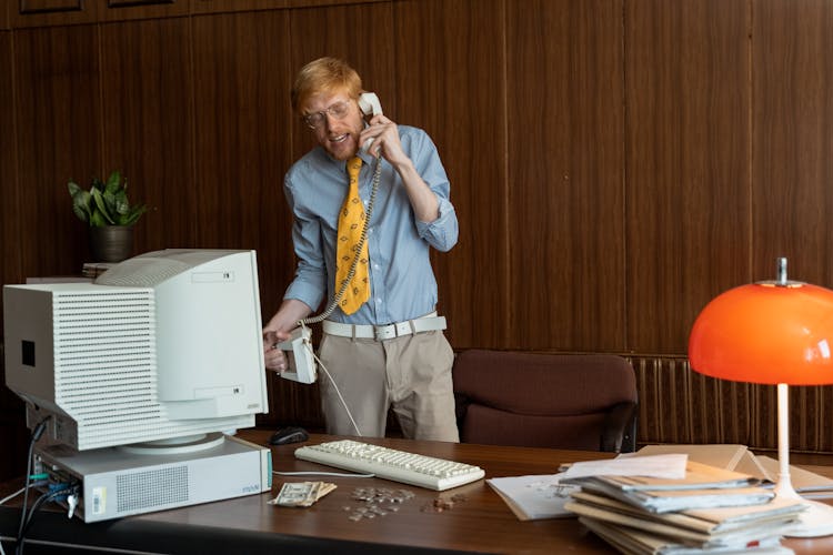 A Man Talking On The Telephone While Standing 