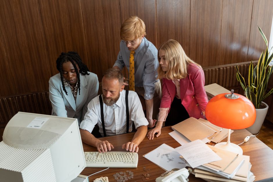 Un grupo diverso de profesionales de negocios trabajando juntos en una oficina vintage.