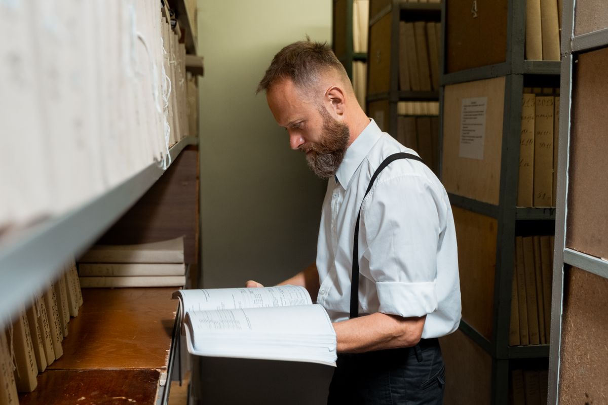 Researcher consulting a volume in an archive store