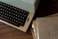 Photo of Documents Beside a Typewriter
